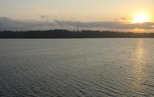 Amazing silhouettes of a mountains and reservoir at colorful sunrise in morning. Amazing panoramic view mountains and water, golden sunlight and clouds in the morning. Wide view. Scenery photo