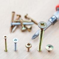 screwdriver and screws wrapped in wooden board photo