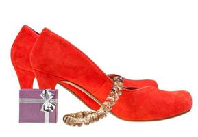 zapatos rojos de tacón alto con una pequeña caja de regalo y un collar foto