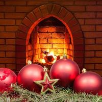 estrella roja y bubles de navidad y chimenea casera foto