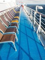 row of empty sunbathing chairs on deck photo