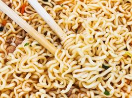 eating instant noodles by wooden chopsticks photo