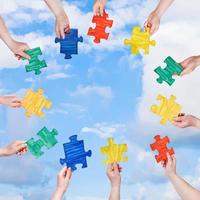 people hands with puzzle pieces with blue sky photo