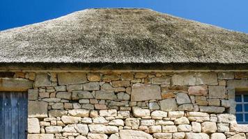 wall and thatched roof of old country house photo