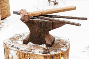 anvil with blacksmith tongs hammer in smithy photo