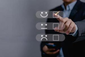 Business satisfaction survey customer service experience concept.Happy Businessman choose to rating checked box on Excellent Smiley Face Rating for a Satisfaction Survey. photo