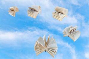 few book fly in blue sky photo