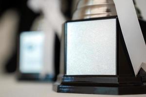 Three Trophies on circle white table with tree leaf background in Seminar hall. photo