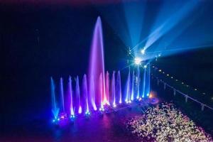 Waterworks at the night on the water surface, decorated and played color by lighting spot light. photo