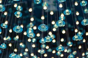 The Wallpaper Turquoise yellow light Crystal Mobile and bokeh light are hanged on the ceiling. photo