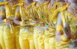 Performance traditional show, with the amazing luxury yellow Indian dress style., They are posting and standing in a row of photo shooting section.