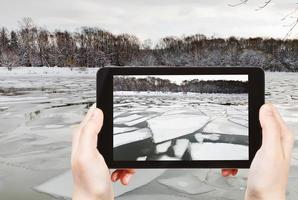 tourist photographs of floating of ice on river photo