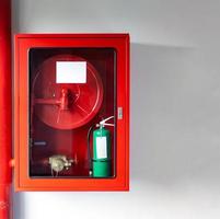 los gabinetes del conjunto de protección contra incendios se resuelven con el extintor de incendios de emergencia y la tubería enrollada foto