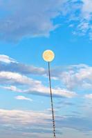 full moon tied on chain soars into blue sky photo