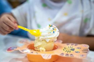 niño está comiendo helado y crema batida en el restaurante de helados foto