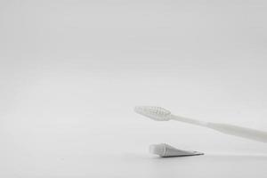 Isolated simple and normal white toothbrush with small toothpaste on the white background in studio light. photo