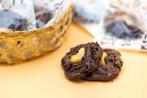 Dark Chocolate Cookies with raisin inside it on the light orange colour background. photo