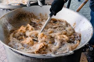 Asian Fried Chicken are fried by palm oil in the large pan. photo