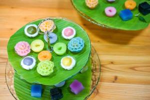 Varieties traditional colorful Thai desserts set NamDokMai steaming flour, PiekPoon black custard, LeumKluen coconut custard steaming bean, KanomChan layer pudding cake photo