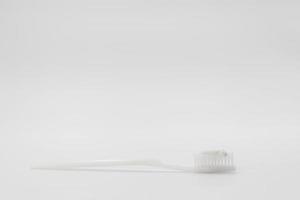 Isolated simple and normal white toothbrush with small toothpaste on the white background in studio light. photo