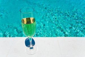 glass of white wine on pool board outdoor photo