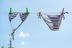 blue Striped swimsuit is dried on clothesline photo