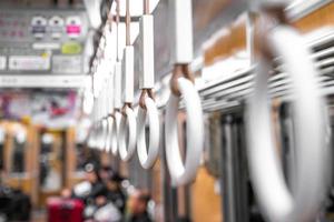cierre la mano plástica del círculo que sostiene en el tren subterráneo japón. foto