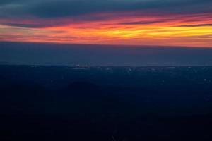 Twilight to Night from the jet plane view red orange blue sky with the light of Thailand city below photo