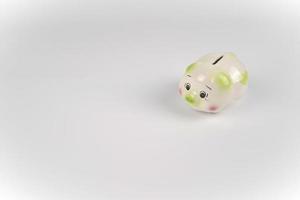 Sad White green and pink piggy back in front of white background. photo