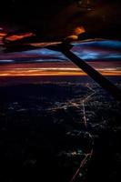 Twilight to Night from the jet plane view red orange blue sky with the light of Thailand city below photo