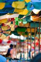 Old and tear Umbrella open to protect the sunshine for Tourists at the Bangsaen Beach Chonburi Thailand. photo