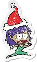 distressed sticker cartoon of a shocked elf girl wearing santa hat vector