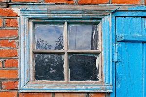 brick wall with window and blue door photo