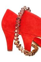 heelpieces of red high heel pumps with necklace photo