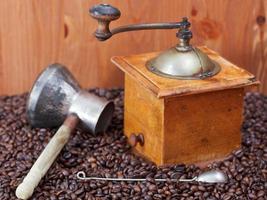 coffee grinder and copper pot on roasted beans photo