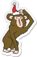 sticker cartoon of a chimp scratching head wearing santa hat vector