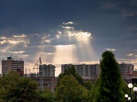 sun rays through clouds illuminate new buildings photo