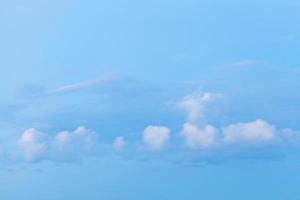 little white clouds in blue dusk sky photo