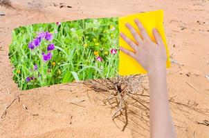 hand deletes sand in desert by yellow cloth photo