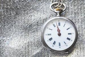 retro pocket watch on silver fabric background photo