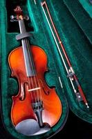 violín con arco en estuche de terciopelo verde foto