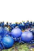 Bolas de Navidad azules y violetas en la rama de un árbol de abeto foto