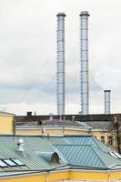 chimneys of district heating over urban roofs photo