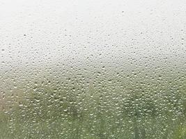 gotas de lluvia en el cristal de la ventana de casa foto