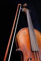 violín y arco sobre fondo negro foto
