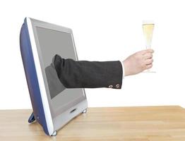 copa de champán en la mano del hombre de negocios se asoma a la televisión foto