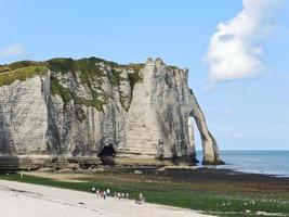 view of cliff with arch on beach of etretat photo