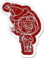 cartoon distressed sticker of a laughing astronaut wearing santa hat vector