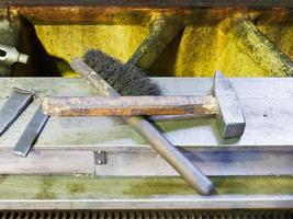 hammer and metal brush on machine frame photo