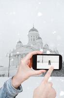 turista tomando fotos de la catedral de helsinki en invierno